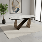 Modern dining table with marble-like surface and bronze legs in a stylish room.