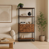 Atticus Bookcase front view with open shelving and carved door styled in a living room