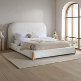 Modern upholstered bed with curved headboard and low profile design.