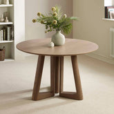 Shop the Cara 120cm Smokey Oak Effect Round Dining Table. Featuring a warm wood-effect finish, sculptural architectural base and elegant circular top.