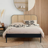 Modern bed blending black finish with natural rattan.