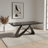 Modern black dining table in a room with abstract art and decor