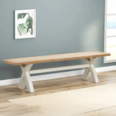 Foxington Painted Cross Leg Dining Bench. A modern bench with a light natural wood seat and white painted X-shaped legs.
