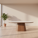 Modern dining table with a wooden base in a bright room with large windows.