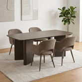 A modern Morocco Matt Chocolate Dining Table with Taupe Fabric Chairs set with a dark brown rectangular table and four upholstered dining chairs in a neutral beige-gray fabric, placed on a light textured rug in a bright dining room.