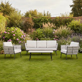 Modern outdoor seating set with ceramic table and cushions.