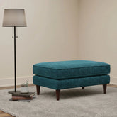 Compact footstool with neutral upholstery and wooden legs.
