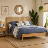 Wooden bed frame with woven rattan headboard and natural finish.