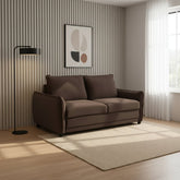 A modern two-seater sofa in dark brown fabric, styled in a contemporary living room with a beige rug, a black floor lamp, a striped accent wall, and a window with sheer white curtains.