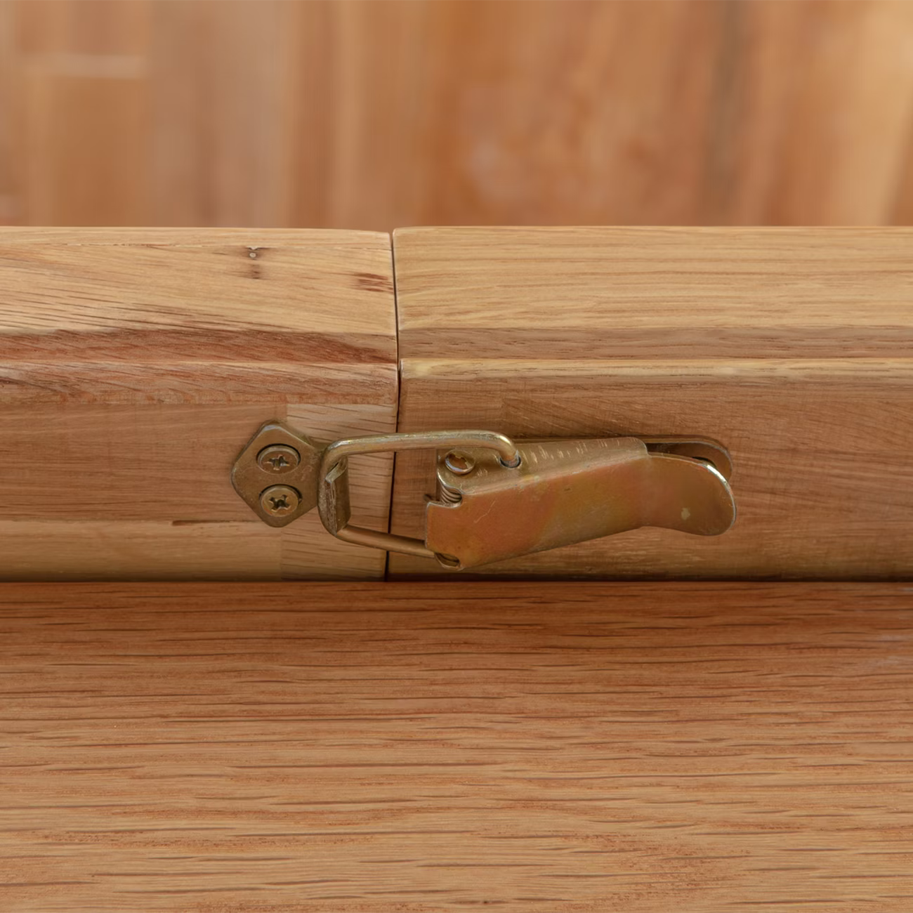 Close-up of a brass Dining table extension latch securing a wooden extension of Chatsworth Oak Extending Dining Table 120-153cm