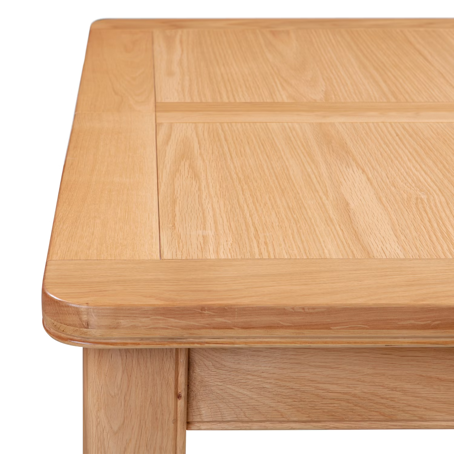 Close-up of a light oak wood table showing the top surface with a raised panel design and rounded corner.