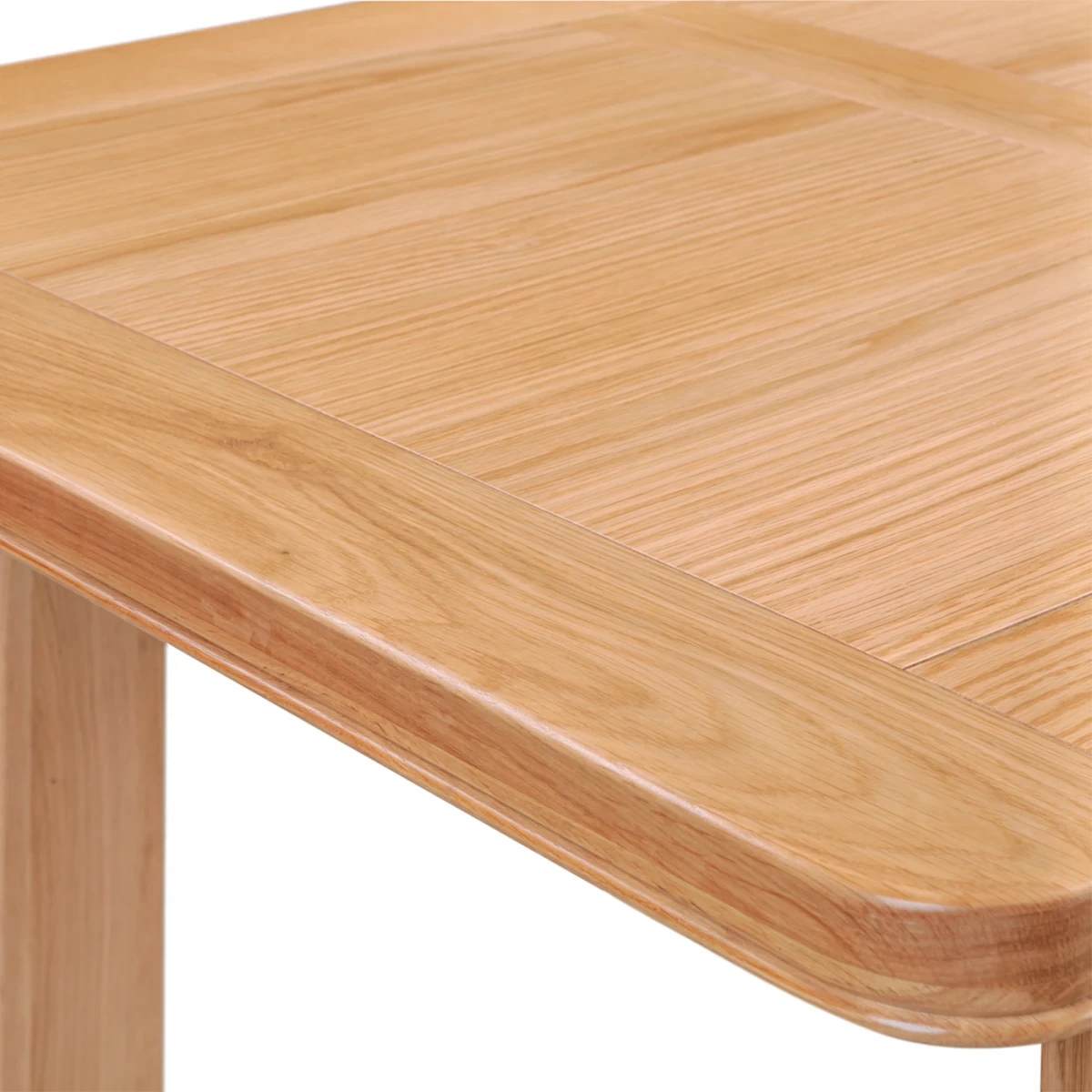 Close-up of Chatsworth Oak Extending Dining Table 120-153cm showing the tabletop grain, rounded edges, and part of the leg against a white background.