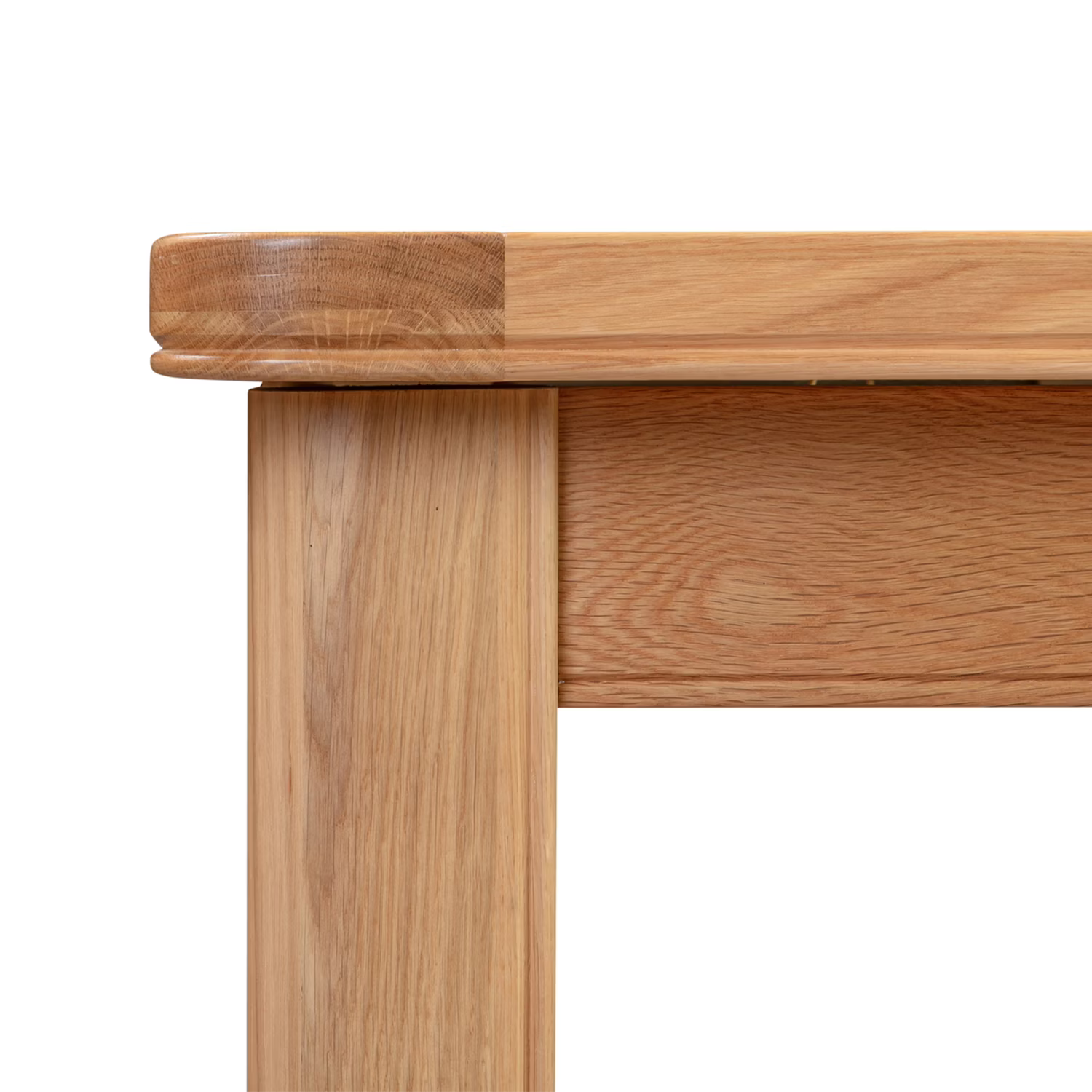 Close-up of a light oak wood table corner showing the mitered top joint, leg, and front apron on a white background.