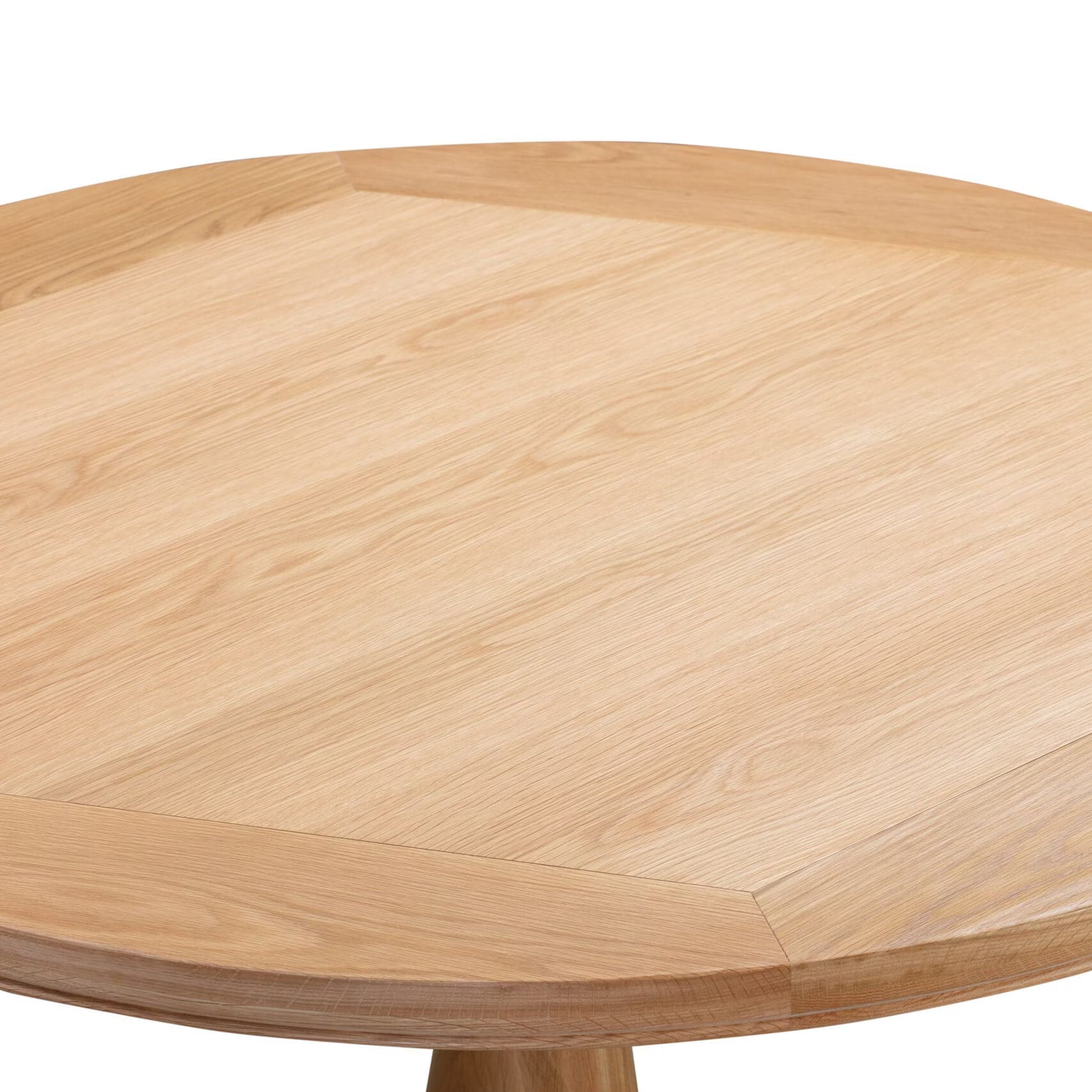 Close-up of a Chatsworth Oak Round Dining Table 120cm top with a light natural oak finish and visible wood grain, showing the corner joint and part of the pedestal leg against a white background.