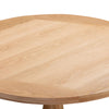 Close-up of a Chatsworth Oak Round Dining Table 120cm top with a light natural oak finish and visible wood grain, showing the corner joint and part of the pedestal leg against a white background.