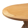 Close-up of a light oak Chatsworth Oak Oval Extending Cross Leg Dining Table showing the curved tabletop edge, wood grain, and part of the pedestal base against a white background.