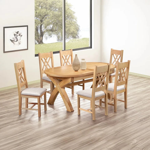 A 7-piece round wooden dining table set with six matching chairs featuring light beige upholstered seats, shown in a bright dining room with wood-look flooring and a large window.