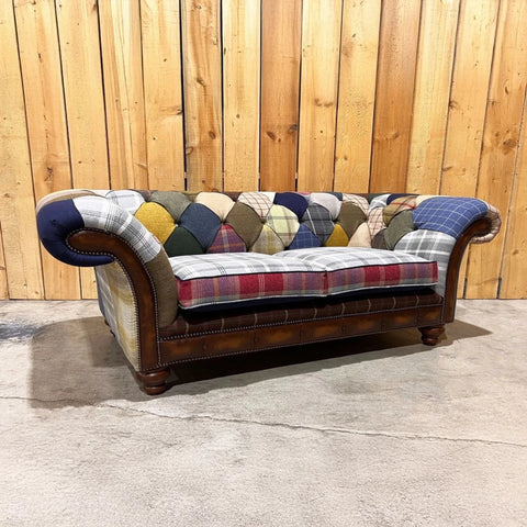 Patchwork sofa with a wooden frame against a wooden fence background