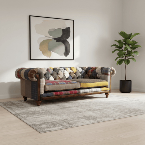 Multicolored patchwork sofa in a living room with abstract art and a plant.