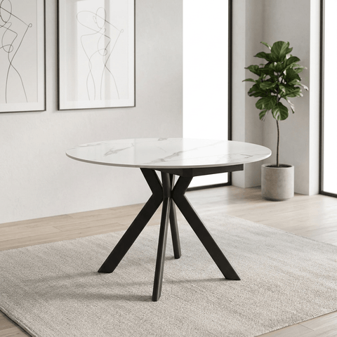A round dining table with a white marble-patterned effect sintered stone ceramic  top and a Grey metal tripod base, shown on a plain white background.