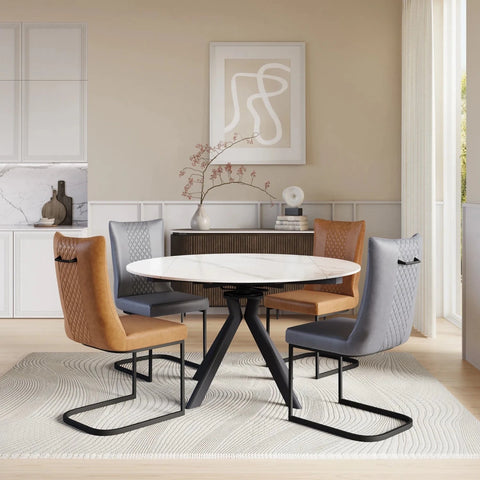 A modern round Swivel Extending dining table with a white marble-look Sintered stone ceramic top and black metal pedestal base, surrounded by four upholstered chairs in tan, gray, and brown tones, set in a bright contemporary dining room.