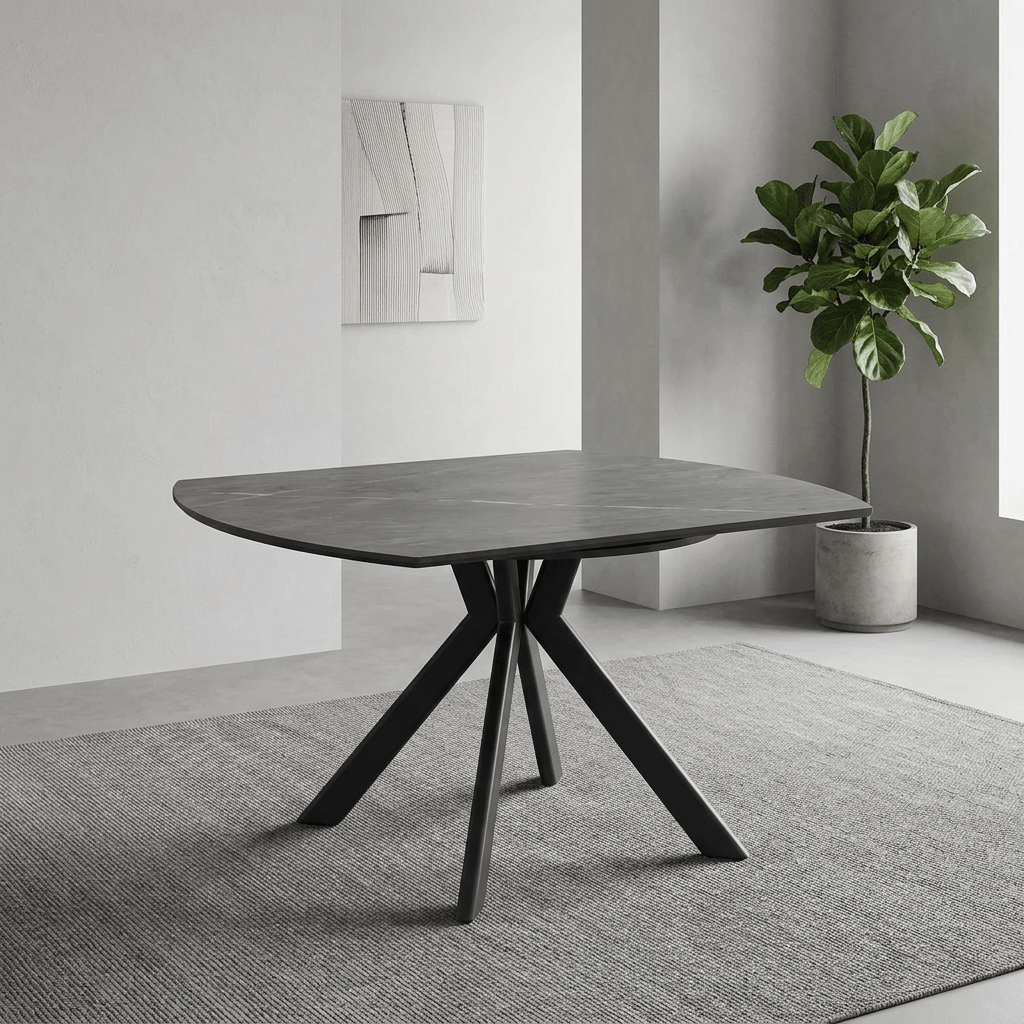 A modern semi-circular dining table with a gray stone-look top and a black three-legged metal base