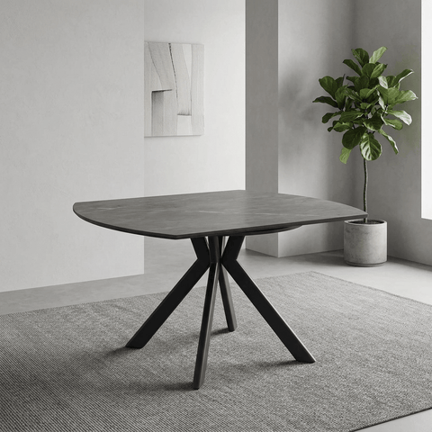 A modern semi-circular dining table with a gray stone-look top and a black three-legged metal base