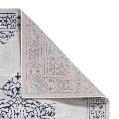 Gray and blue patterned rug corner on a white background