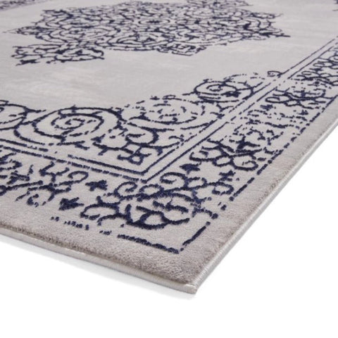 Close-up of a patterned rug with blue designs on a white background
