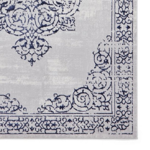 Close-up of a patterned rug with intricate designs on a light gray background