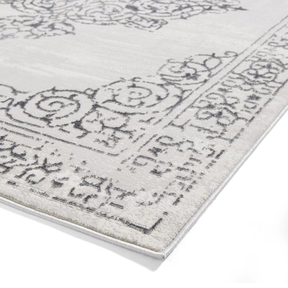 Close up corner of Artemis Silver rug styled in a modern living room