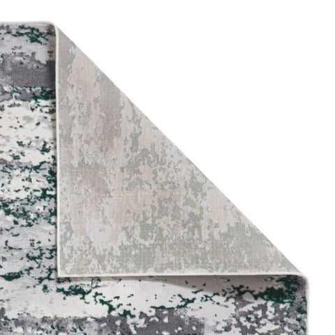 Corner of a patterned rug with gray, white, and green colors on a white background