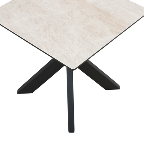 Square table with light-colored top and black metal legs on a white background