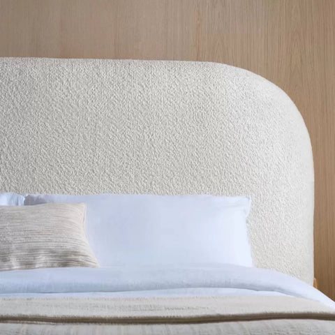 Fabric upholstered headboard with smooth curves and soft padding.