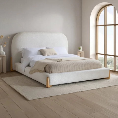 Modern upholstered bed with curved headboard and low profile design.