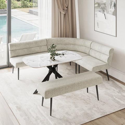 A modern curved upholstered banquette seating set with a matching bench, arranged around a round white marble-top table in a bright dining or lounge area with a window, pool view, and light rug.