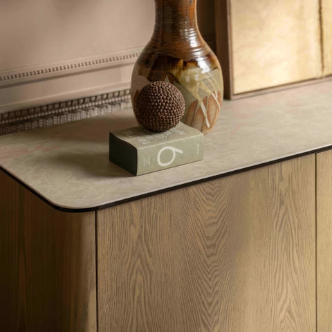 Close up of Arlo Cream Ceramic 3 Door Sideboard with push-to-open doors, sculptural ash wood legs and a stone-inspired ceramic top. 