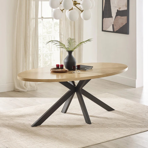 Shop the Bondi 200cm Oval Dining Table featuring a light oak veneer top, curved surfboard design and striking black metal spider base. Modern dining style.