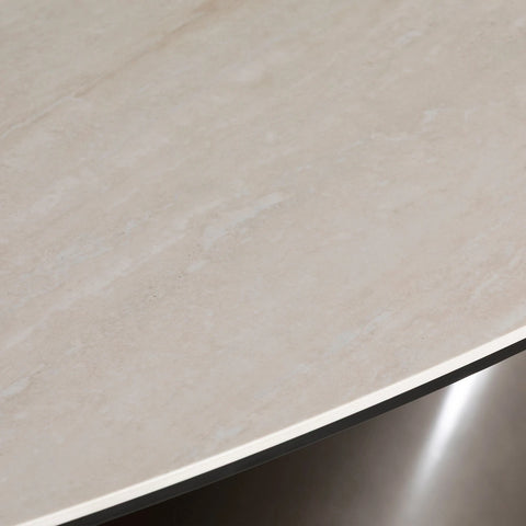 Close-up of a beige ceramic top of Brann oval dining table showcasing ceramic top and metal base