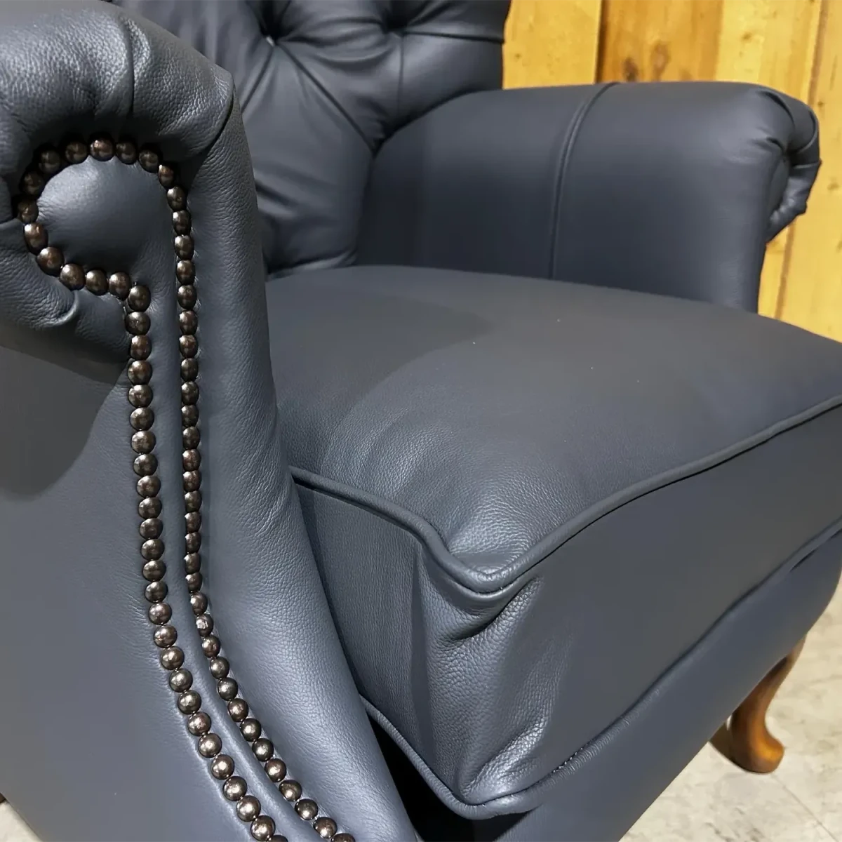 Gray leather armchair with a decorative studs on the arms