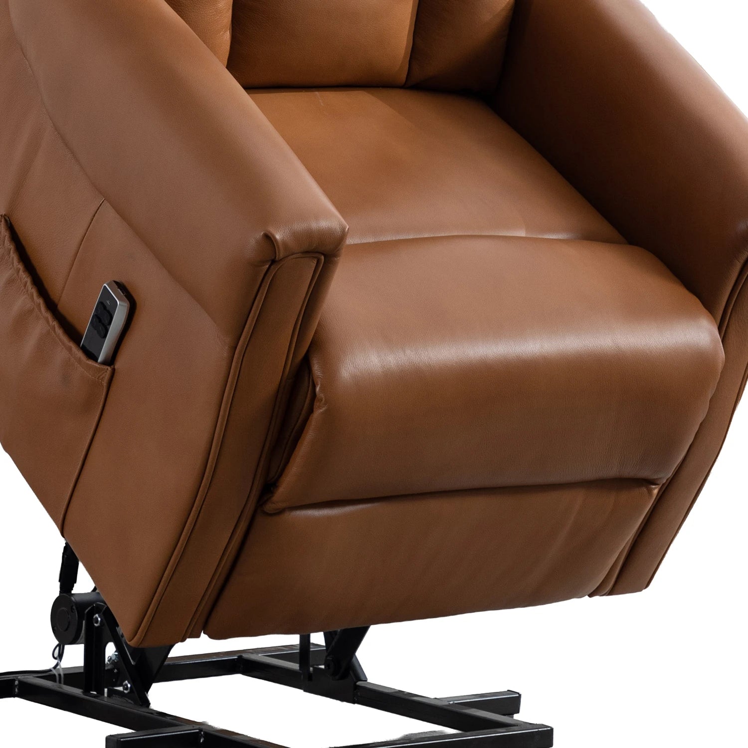 A close-up of a Camel leather riser recliner chair with a side pocket holding a remote, shown on a white background with part of the black metal base visible.