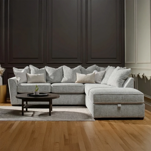 Luxury Buoyant Caspian Marlon light grey corner sofa with plush scatter cushions and sleek dark wood feet.