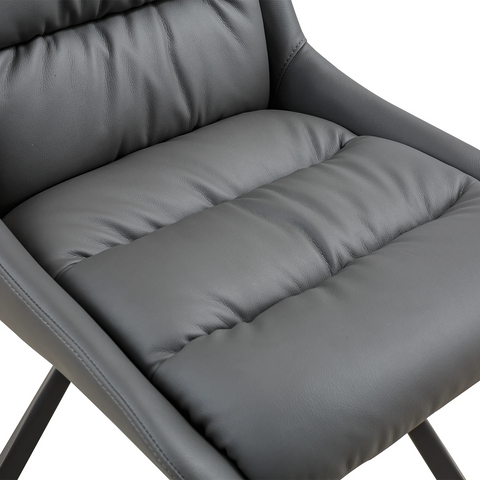 Close-up of a dark gray upholstered chair seat with padded tufted sections and smooth leather-like material, shown against a white background.