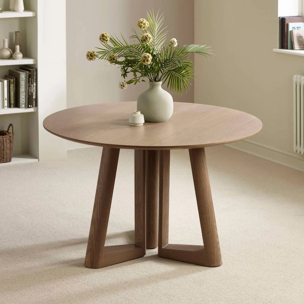 Shop the Cara 120cm Smokey Oak Effect Round Dining Table. Featuring a warm wood-effect finish, sculptural architectural base and elegant circular top.