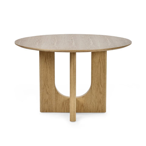A round wooden dining table with a light oak finish, featuring a central pedestal base with a U-shaped cutout, shown on a plain white background.