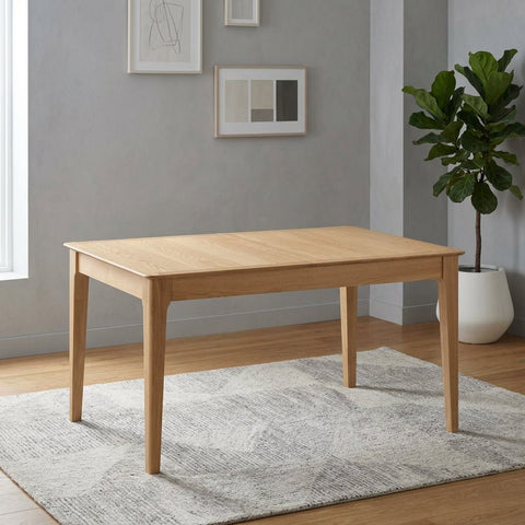 A light natural oak rectangular dining table with four tapered legs, shown from a three-quarter angle on a solid white background.