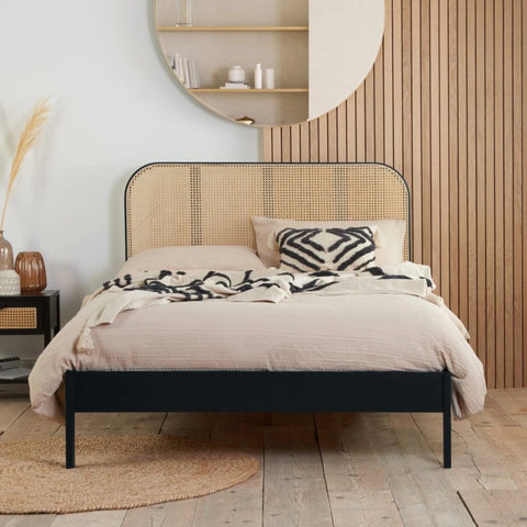 Modern bed blending black finish with natural rattan.