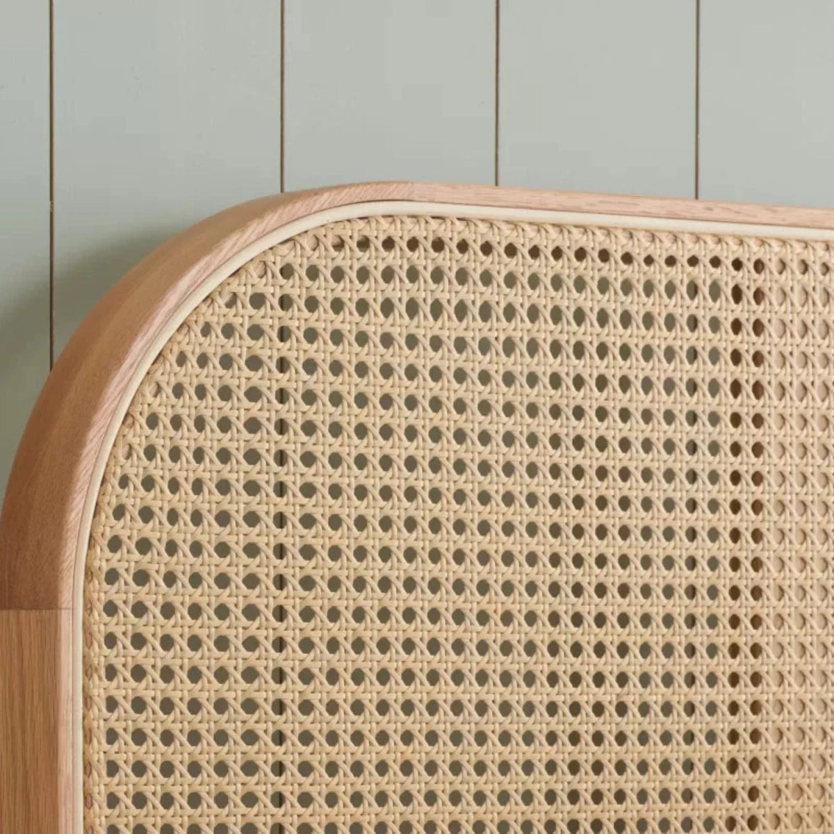 Curved rattan headboard with natural woven texture.