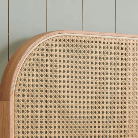 Curved rattan headboard with natural woven texture.