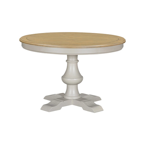 A round pedestal dining table with a light natural wood top and a distressed grey painted base 